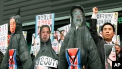 Nam người biểu tình Nam Triều Tiên trưng hình nộm của lãnh đạo Bắc Triều Tiên Kim Jong Un và cha, cố lãnh đạo Kim Jong Il (phải) cùng ông nội Kim Il Sung tại một cuộc biểu tình chống Bắc Triều Tiên tại Seoul, ngày 15/4/2013. 