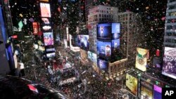 FILE - Confetti drops over the crowd at midnight during the New Year's celebration in Times Square as seen from the Marriott Marquis in New York, Jan. 1, 2018. 