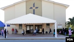 People practice social distancing as they wait at a COVID-19 testing site at Sacred Heart Church, Tuesday, May 5, 2020, in Lake Worth, Fla. (AP Photo/Lynne Sladky)
