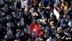 Tunisian police block protesters from accessing the parliament building, in Tunis, Jan. 26, 2021.