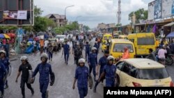 Escorte policière lors d'une manifestation antigouvernementale dans le quartier Ngiri-ngri de Kinshasa, le 3 novembre 2021.