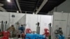 Foto tomada de las redes sociales muestra a pacientes en el Hospital Temporal del Parque de la Industria, en la Ciudad de Guatemala, en sillas plásticas o algunos en el suelo, todos conectados a oxígeno. 