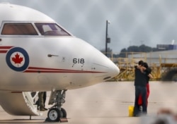 Former diplomat Michael Kovrig embraces his wife Vina Nadjibulla following his arrival on a Canadian air force jet after his release from detention in China, at Pearson International Airport in Toronto on September 25, 2021. (Chris Halgren/Reuters)