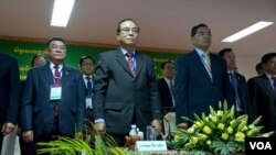 Election reform working group co-chairs Bin Chhen (center) of the Cambodian People's Party (CPP) and Kuoy Bunroeun (right) of the Cambodia National Rescue Party (CNRP) stand up at the opening of a national workshop on two new election draft laws on Monday, March 9, 2015 at the National Assembly before the discussion. (Neou Vannarin/VOA Khmer) 