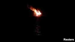 Flames are seen after an explosion at an oil rig in Lake Pontchartrain, in Louisiana, in this still image taken from social media video taken Oct. 15, 2017. 