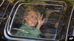 Democratic presidential candidate Hillary Clinton waves from her motorcade vehicle as she arrives for a fundraiser at the home of Justin Timberlake and Jessica Biel in Los Angeles, Aug. 23, 2016. 