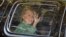Democratic presidential candidate Hillary Clinton waves from her motorcade vehicle as she arrives for a fundraiser at the home of Justin Timberlake and Jessica Biel in Los Angeles, Aug. 23, 2016. 