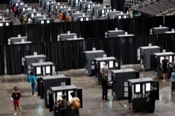 People cast their ballots during early voting for the upcoming presidential elections inside of The Atlanta Hawks' State Farm Arena in Atlanta, Georgia, Oct. 12, 2020.