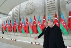 Turkey's President Recep Tayyip Erdogan, right, is welcomed by Azerbaijan's President Ilham Aliyev, center, in Baku, Azerbaijan, Thursday, Dec. 10, 2020. The parade was held in celebration of the peace deal with Armenia over Nagorno-Karabakh, with…