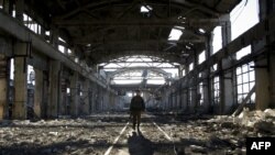 FILE - A Ukrainian serviceman walks through the rubble of a destroyed workshop after fighting with pro-Russian separatists in Avdiivka, Donetsk region, March 31, 2017. 