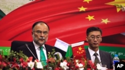 FILE - Ahsan Iqbal, left, Pakistan's minister of planning and development, and Yao Jing, Chinese ambassador to Pakistan, attend the launch of a CPEC long-term cooperation plan in Islamabad, Dec. 18, 2017. The Afghan Taliban have secured an agreement to extend CPEC to Afghanistan.