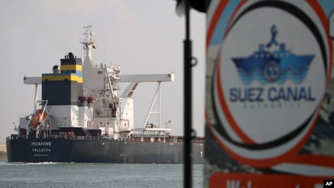 FILE - A cargo ship sails past the town of Ismailia, Egypt, March 30, 2021.