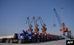 FILE - Chinese trucks stand on a pontoon during the opening of a trade project in Gwadar port, 700 kilometers west of Karachi, Pakistan, Nov. 13, 2016.
