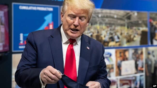 President Donald Trump duke inspektuar një maskë mbrojtëse
