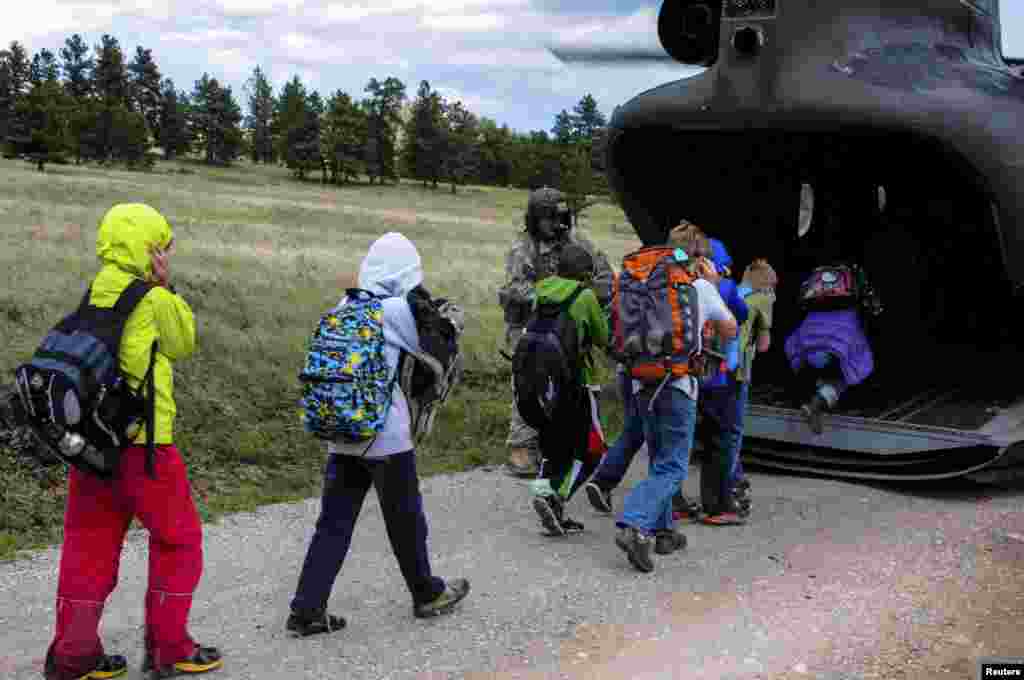 Children board a rescue helicopter flown by the U.S. Air National Guard after severe flooding shut down major roads leading out of Jamestown, Colorado, Sept. 14, 2013. (U.S. Air National Guard Handout photo)