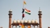 مظاہرین احتجاج کے دوران لال قلعے پر بھارتی ترنگے کے اُوپر سکھوں کا مذہبی پرچم 'نشان صاحب' لگا رہے ہیں۔ 