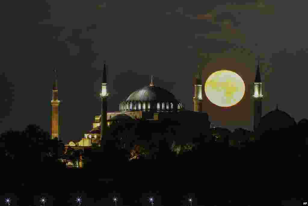 The full moon rises behind the Byzantine-era Hagia Sophia, in the historic Sultanahmet district of Istanbul, Turkey.
