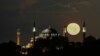 The full moon rises behind the Byzantine-era Hagia Sophia, in the historic Sultanahmet district of Istanbul, Turkey.