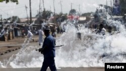 Un policier va se mttre à l'abri après avoir lancé des grenades lacrymogènes aux manifestants à Bujumbura, Burundi, le 2 juin 2015.