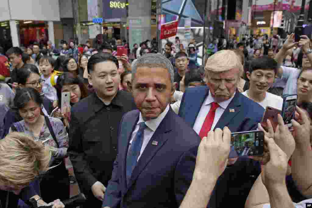 Impersonators of North Korean leader Kim Jong Un, former U.S. President Barack Obama and U.S. President Donald Trump pose with their fans on a street during an event to promote the Hong Kong Rugby Sevens.