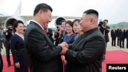 North Korean leader Kim Jong Un welcomes Chinese President Xi Jinping at the Pyongyang International Airport in Pyongyang, North Korea, in this undated photo released June 21, 2019 by North Korea's Korean Central News Agency.