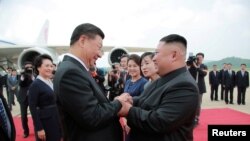 FILE - North Korean leader Kim Jong Un welcomes Chinese President Xi Jinping at the Pyongyang International Airport in Pyongyang, North Korea, in this undated photo released June 21, 2019 by North Korea's Korean Central News Agency.