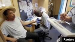 A man in Boston having blood taken from his finger for a cholesterol test