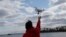 Drone operator Parker Gyokeres helps to retrieve a drone after photographing over Hart Island in New York, April 29, 2018.