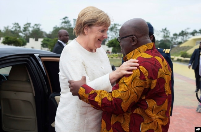 German Chancellor Angela Merkel, left, is welcomed by Ghana's President, Nana Akufo-Addo, right, at the Presidential palace in Accra, Ghana, Aug 30, 2018.