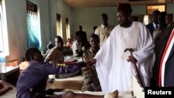 FILE - South Sudan's President Salva Kiir greets Sudan People's Liberation Army soldiers receiving treatment at the Juba Military hospital in the capital Juba, Dec. 26, 2016. 