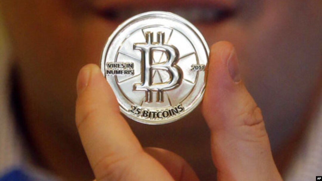 Seorang pria menunjukkan token 25-Bitcoin (foto: ilustrasi). Bank JP Morgan Chase resmi meluncurkan mata uang kripto (cryptocurrency) sendiri hari Kamis (14/2). 