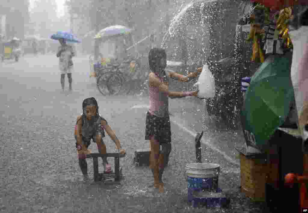 بازی کردن دختربچه در زیر باران های سیل آسا در فیلیپین