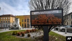 A municipality panel reads in Italian " Corona Virus, as a precaution the population is invited to stay home ", in Casalpusterlengo, Northern Italy,Feb. 23, 2020.