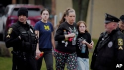 Orang tua beserta sejumlah murid bergerak meninggalkan tempat perlindungan menyusul insiden penembakan di Abundant Life Christian School di Wisconsin, pada 16 Desember 2024. (Foto: AP/Morry Gash)