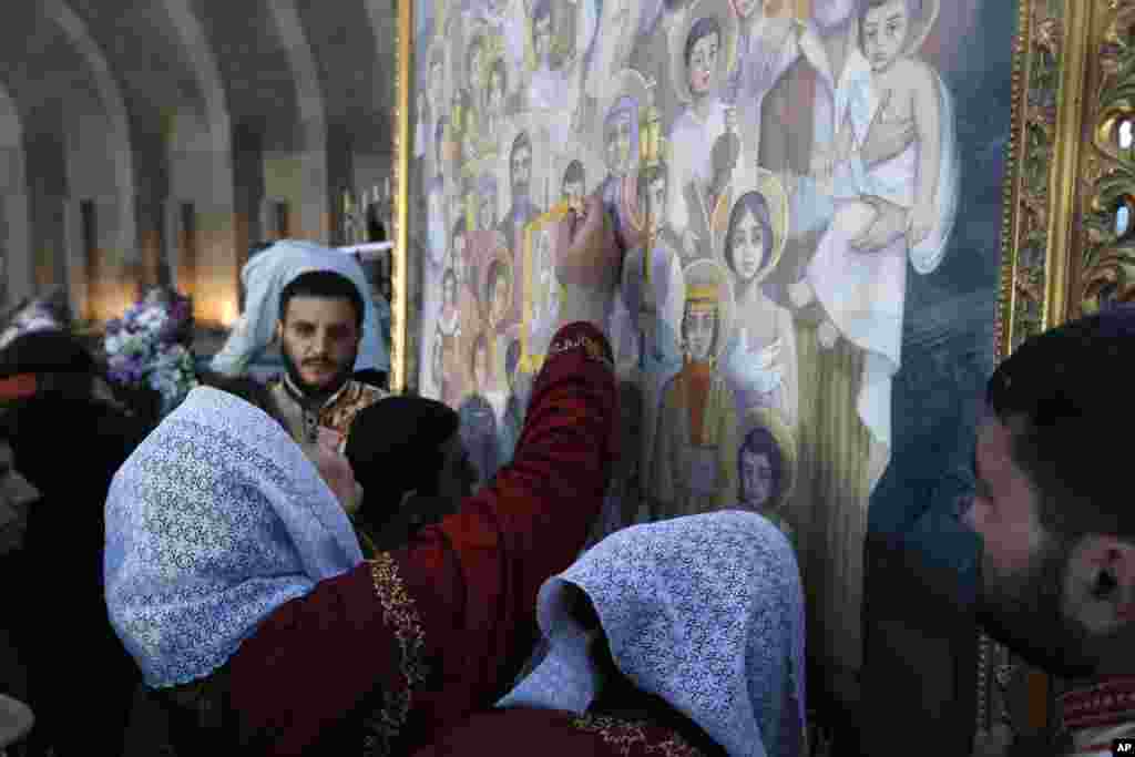 Armenians kiss the icon with canonized victims of massacres in in Echmiadzin, the religious center of the Armenian Church outside the capital Yerevan, Armenia, April 23, 2015. 