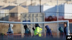 FILE - Teen migrants walk in line inside the Tornillo detention camp in Tornillo, Texas, Dec. 13, 2018. Thousands more migrant children may have been split from their families than the Trump administration previously reported.