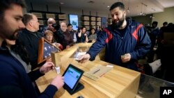 Stephen Mandile, right, an Iraq War veteran from Uxbridge, Massachusetts, is the first to purchase recreational marijuana at the Cultivate dispensary on the first day of legal sales, Nov. 20, 2018, in Leicester, Massachusetts.
