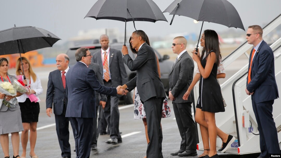 Menlu Kuba Bruno Rodriguez (kiri) menyalami Presiden AS Barack Obama saat tiba di bandara Jose Marti di Havana, Kuba, Minggu siang (20/3).