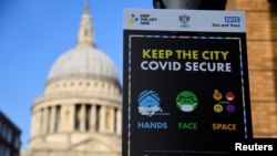 FILE - A public health information sign is seen with St. Paul's Cathedral seen behind amidst a lockdown during the spread of the coronavirus disease (COVID-19) pandemic, London, Britain, Jan. 7, 2021. 