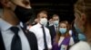 French President Emmanuel Macron, second from left, listen to members of local NGOs unloading emergency aid delivered for Lebanon at Beirut port, Sept. 1, 2020. 