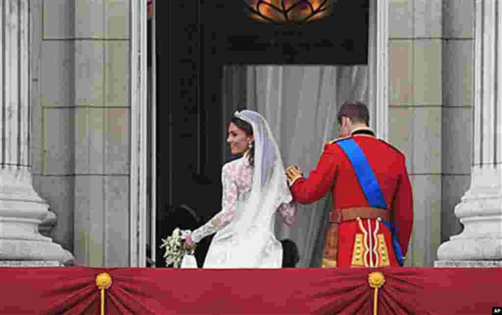Принцот Вилијам и сопругата Кејт влегуваат во Бакингамската палата по венчавката. (AP Photo/Matt Dunham)
