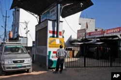 FILE - A Nepalese man reads a notice at a closed fuel station in Kathmandu, Nepal, Oct. 8, 2015. Struggling with a fuel shortage after Indian shipments went on hold, Nepal is looking to import fuel from China.