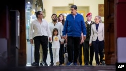 El presidente venezolano Nicolás Maduro, vestido con chaqueta azul, recibe en el Palacio de Miraflores, en Caracas, al empresario colombiano Alex Saab y a su familia tras su liberación por parte de Estados Unidos, este miércoles 20 de diciembre de 2023.