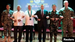 Philippines and U.S. officials link arms during the opening ceremony of the 2016 Balikatan military exercises at the Armed Forces of the Philippines (AFP) headquarters in Camp Aguinaldo, Quezon city, metro Manila April 4, 2016.