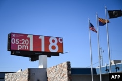 FILE - A billboard displays a temperature of 118 degrees Fahrenheit (48 degrees Celcius) during a record heat wave in Phoenix, Arizona on July 18, 2023.