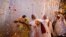 Widows throw flowers into the air during a holi celebration at the Meera Sahavagini ashram in Vrindavan in the northern Indian state of Uttar Pradesh, Mar. 24, 2013.