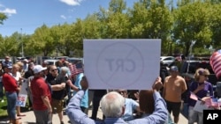 Seorang pria mengacungkan poster yang berisi protes terhadan Teori Ras Kritis dalam demo di luar Dewan Sekolah Distrik Washoe County di Reno, Nevada, 25 Mei 2021. (Foto: Andy Barron/Reno Gazette-Journal via AP, File)