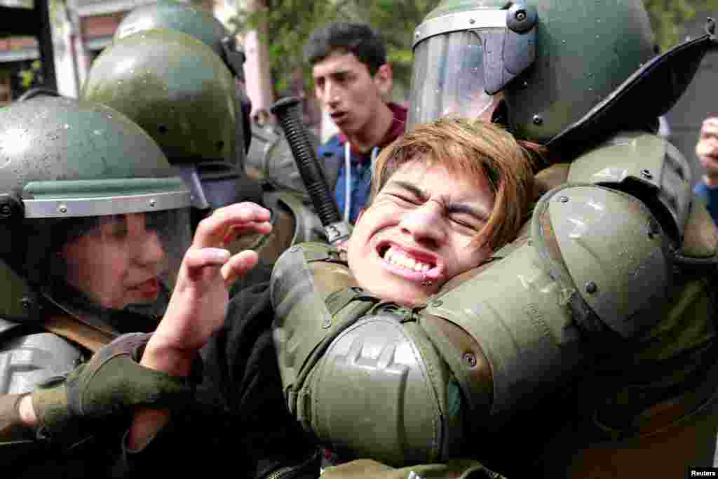 A demonstrator is detained during a rally to request change in the education system in Santiago, Chile.