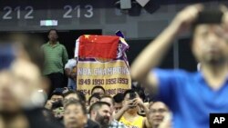 在布魯克林籃網隊與洛杉磯湖人隊在上海的季前賽期間，一名球迷用中國國旗蓋住NBA旗幟 (2019年10月10日)