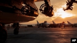 In this Russian Defense Ministry Press Service photo, a Russian Su-25 ground attack jet is parked at Hemeimeem air base in Syria, with Su-24 bombers seen in the background, Dec. 18, 2015.